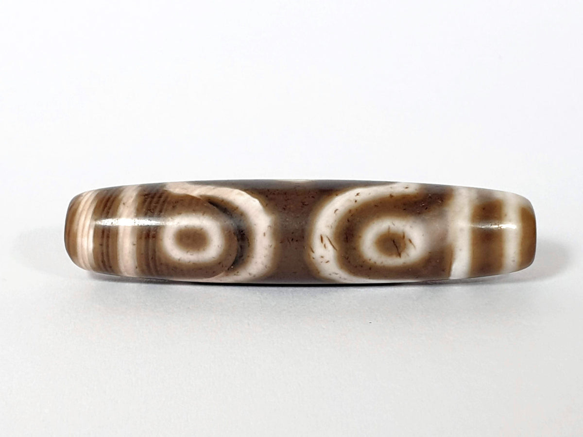 Qing Dynasty three eye dzi — reverse face, two open ring eyes, brown speckle across cream zones, At-0426-3EQ2