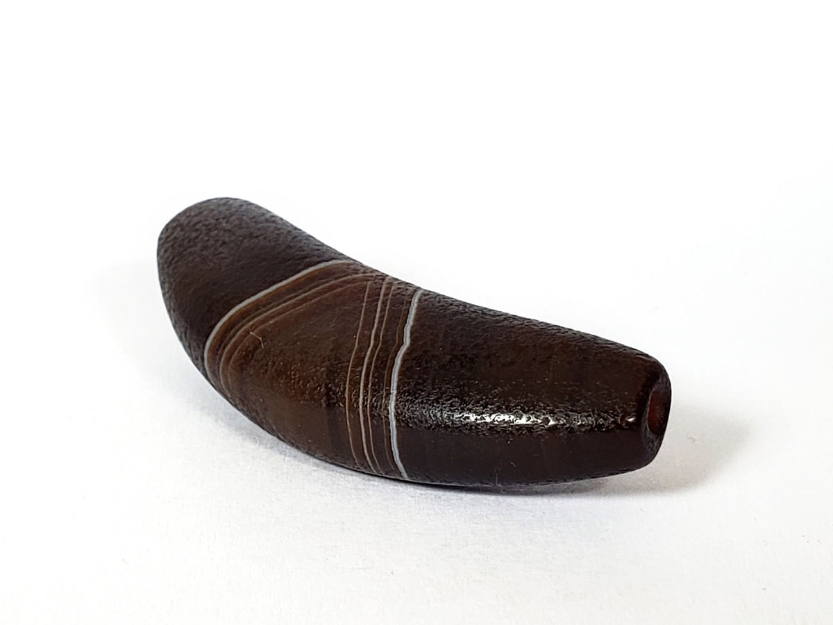 Bow-shaped natural banded agate dzi bead with brown and white stripes, polished surface, and center drill hole