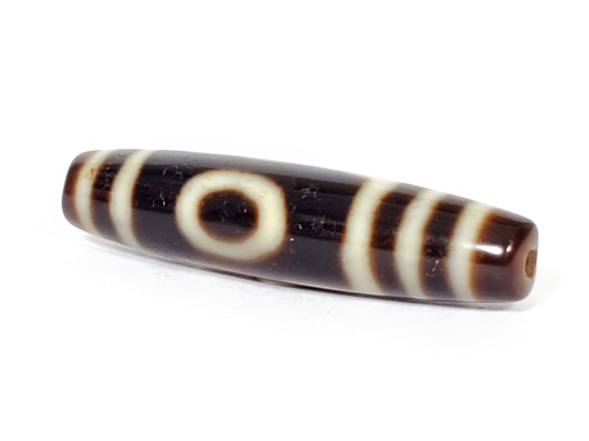 V-070226-OEM dzi bead, diagonal view showing drill hole and full stripe pattern, dark brown, unretouched.