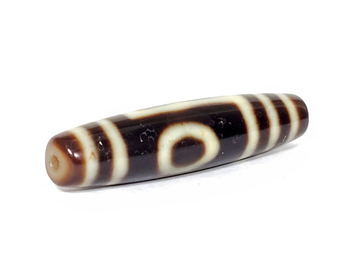 V-070226-OEM dzi bead, close view of central eye motif, dark brown agate, unretouched photo.