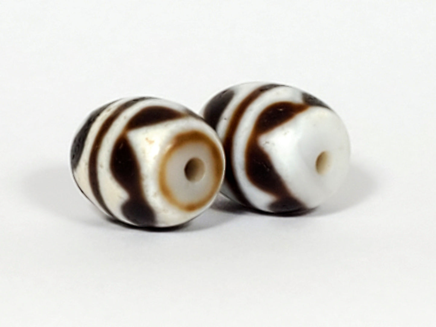 V-041122-DTT pair vintage double tiger tooth dzi, drill end view, Bead A honey-tan ring, Bead B cream-white, unretouched