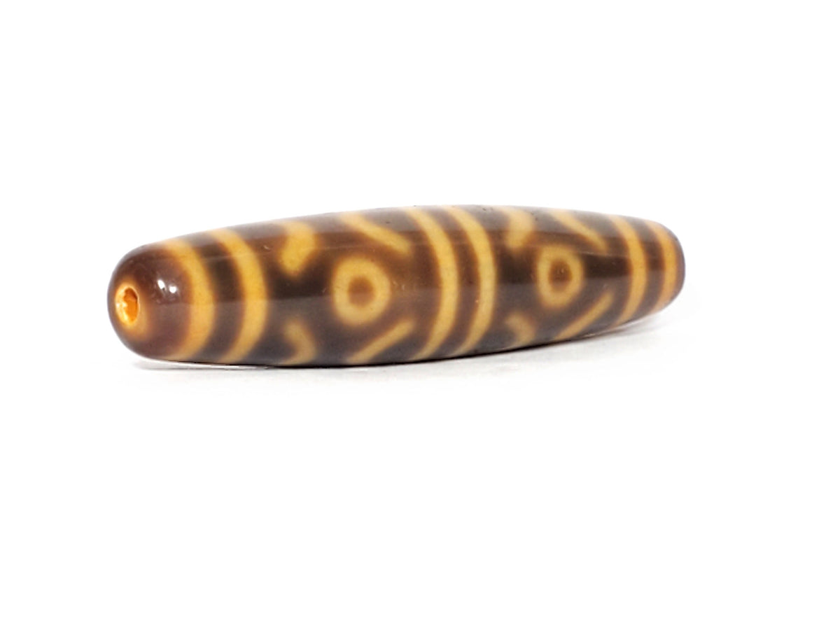 At-053126-6ETT, antique six eye & tiger tooth dzi, 57.9×12.9mm, honey-gold motif on chocolate-brown, unretouched