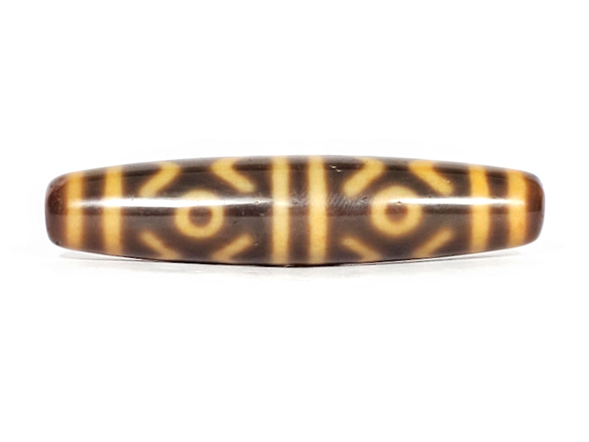 At-053126-6ETT, opposite end-cap angled view, honey-gold cap with hole, chocolate-brown body, six eye motif, unretouched