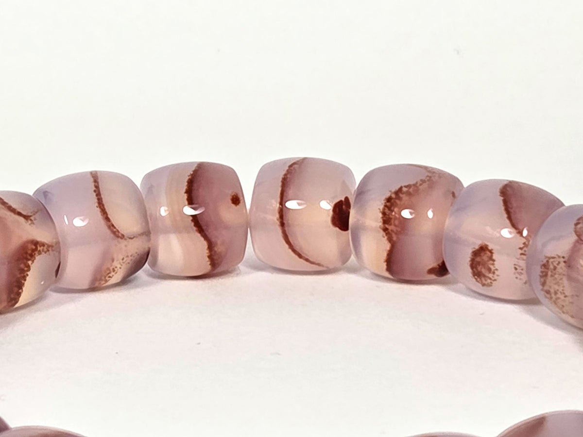 N-030526-CB2 arc detail, pale lavender-blush translucent chalcedony, rust-brown banding, gold spacers, unretouched