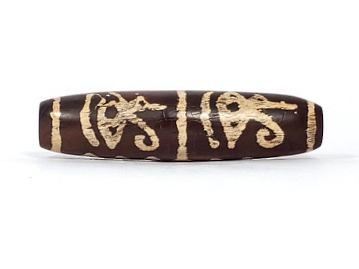 Tibetan dzi bead dark brown agate etched cream symbols patina cylindrical oval shape drilled ancient motif