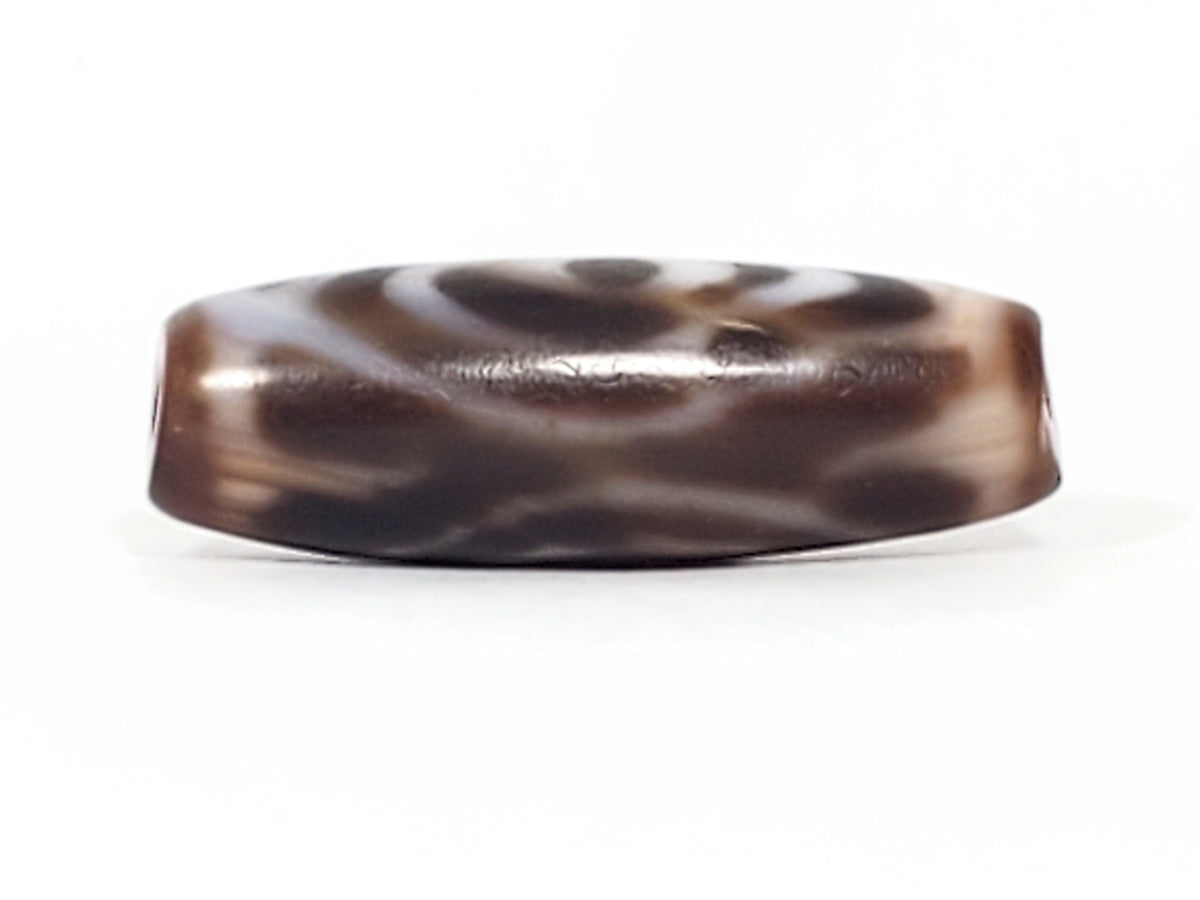 Ancient Tibetan dzi bead, double heaven's gate motif, dark brown agate with white wave patterning, glossy patina, bloodspots visible