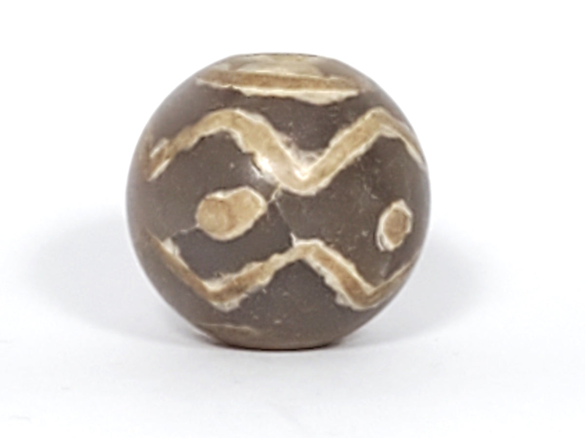 Ancient round dzi bead, grey-brown agate, double wave zigzag motif, cream eye spots, visible drill hole, aged patina surface