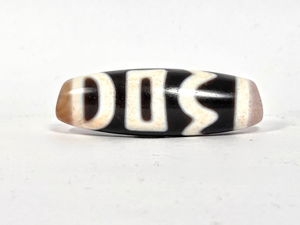 Antique Tibetan dzi bead four activities motif black white agate etched pattern bloodspots aged patina oval barrel shape