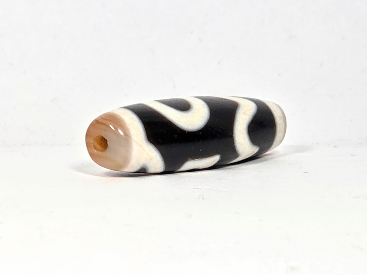 Antique Tibetan Dzi bead Four Activities motif black white agate wave pattern visible drill hole natural patina