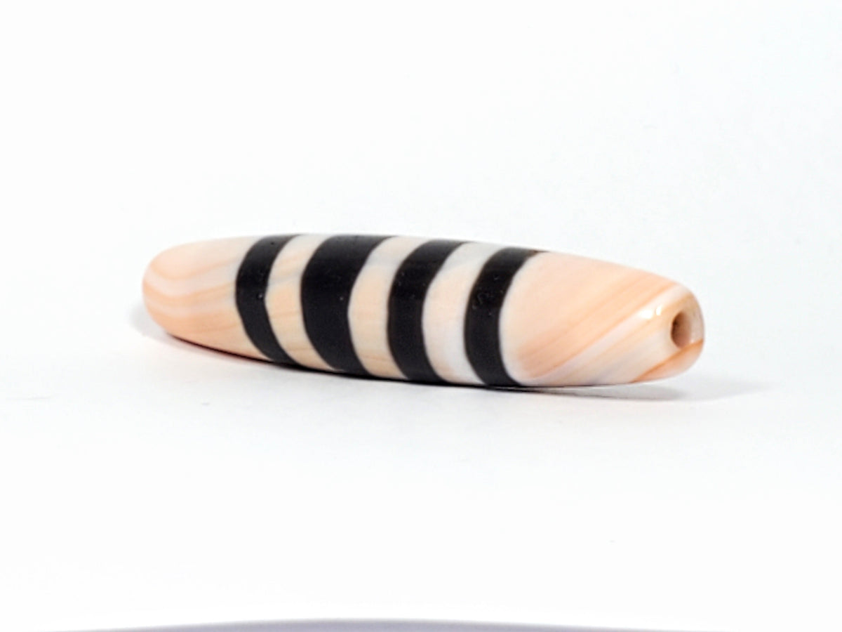 Antique Nepalese seven-stripe chung dzi bead, peach agate, black bands, visible drill hole, natural patina, bloodspot inclusions