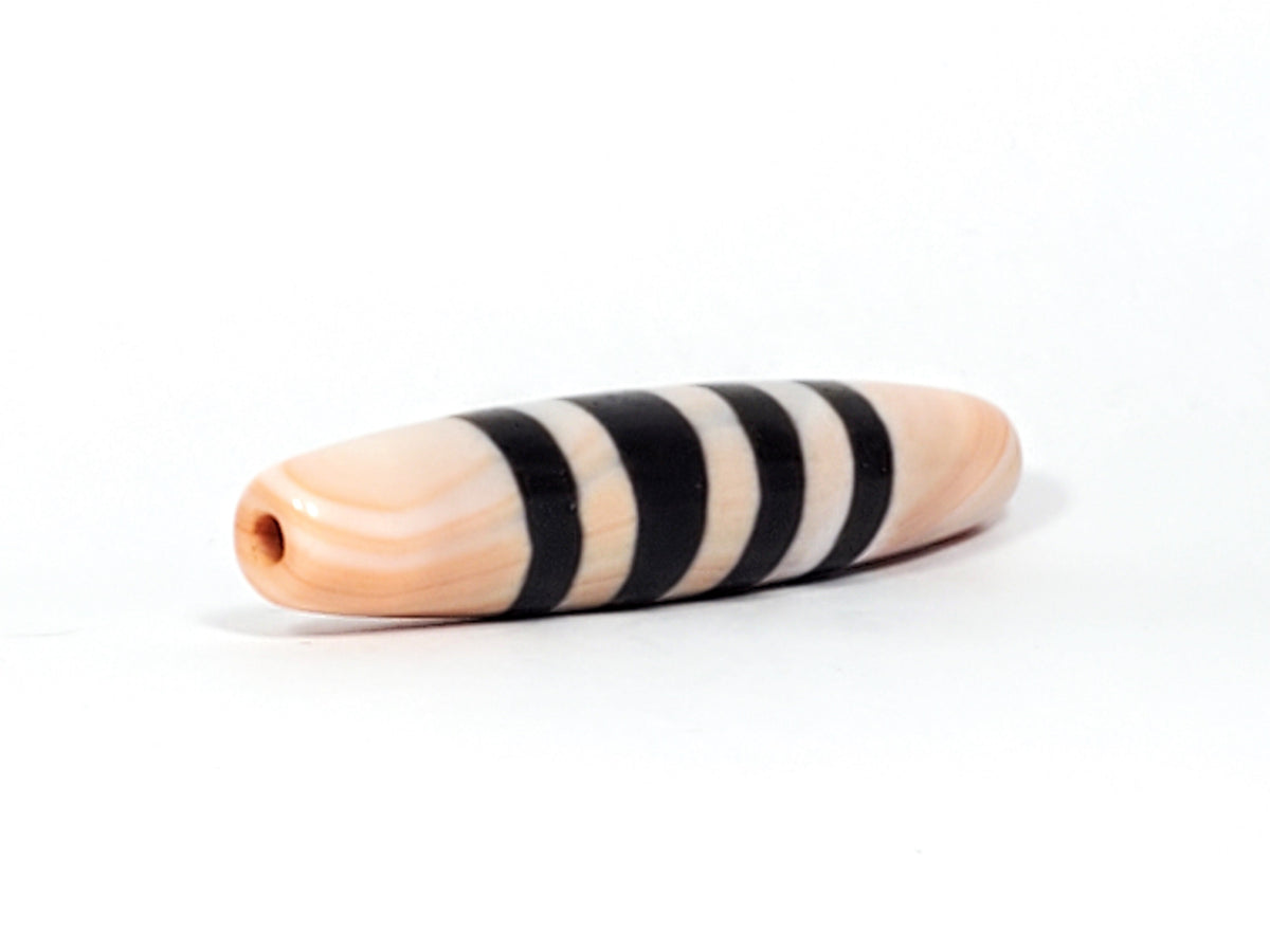 Antique Nepalese seven stripe chung dzi bead, peach agate, black bands, visible drill hole, aged patina, elongated barrel shape