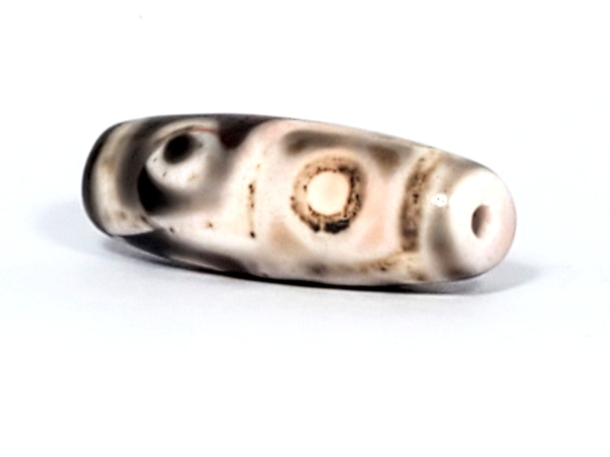 Six Eye Dzi bead, pale warm-brown agate with cinnabar bloodspots, 35mm, polished surface with visible drill holes
