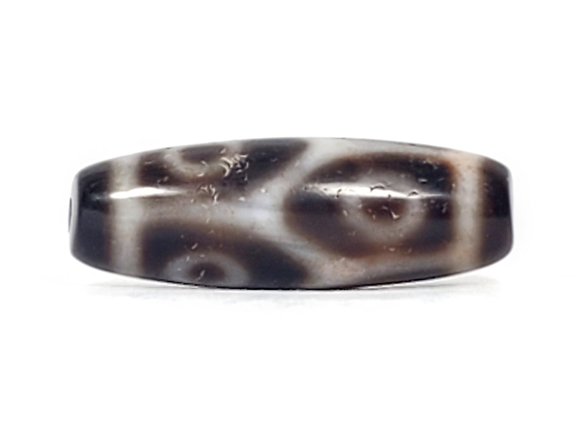 Antique Tibetan six-eye lotus dzi bead, dark agate, white swirl motifs, bloodspots, visible drill hole, aged patina