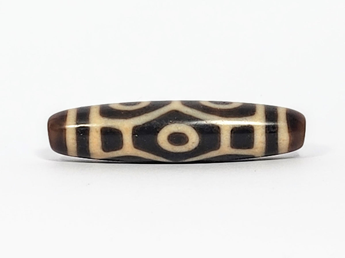 Antique Naga dzi bead face B showing architectural body scale with squared dark panels and central eye, At-050725-6EN3
