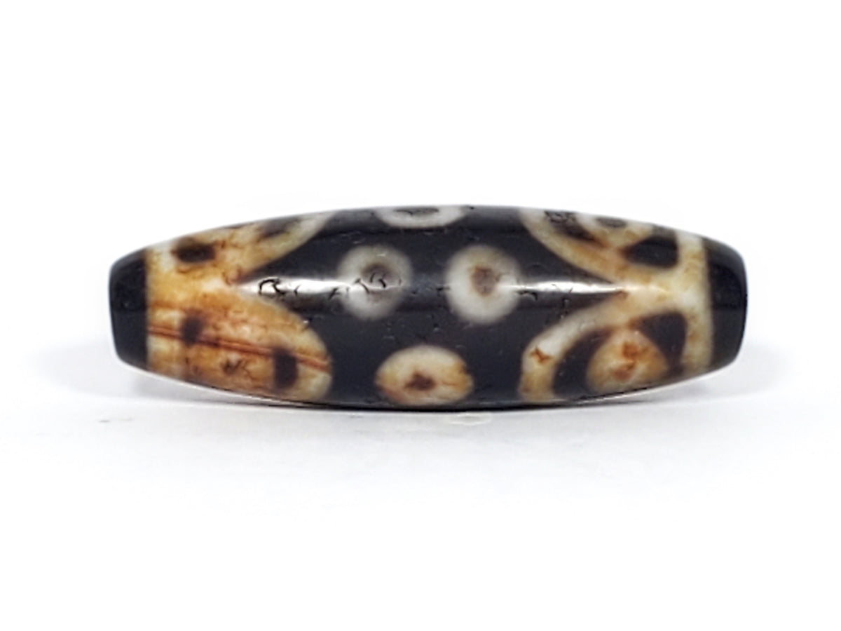 Antique Tibetan 15-eye dzi bead, dark agate, cream eye motifs, aged patina, natural bloodspots, weathered surface texture