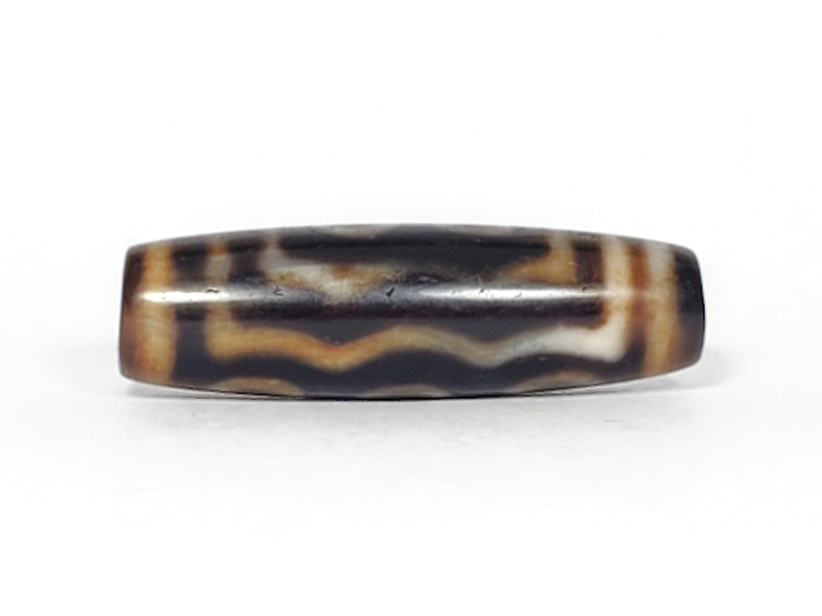 Antique five-eye dzi bead, dark agate, cream wave patterns, bloodspot markings, aged patina, elongated barrel shape