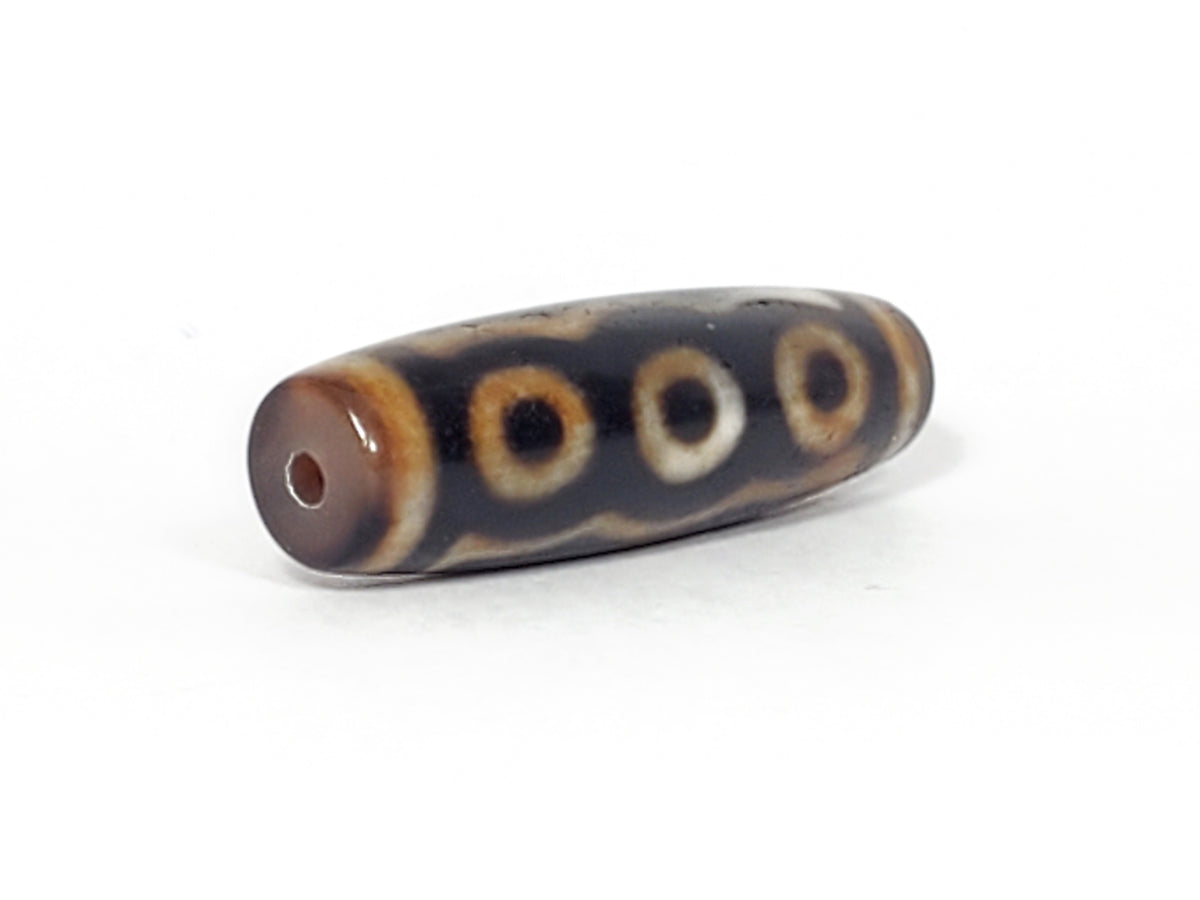Antique five-eye dzi bead, dark agate, brown-white eye motifs, cinnabar bloodspots, visible drill hole, aged surface texture