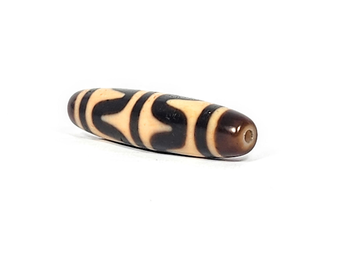 Opposite end of antique Tibetan Double Wave dzi bead showing brown agate cap and small drill hole, At-052526-DW3