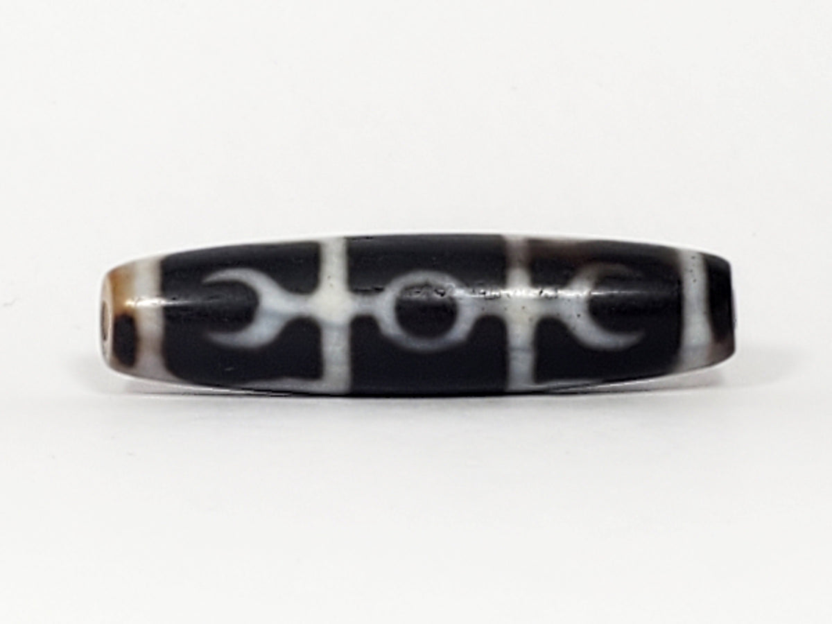 Antique Tibetan dzi bead, black agate, white Guru Rinpoche scepter motif, visible bloodspots, drilled ends, aged patina