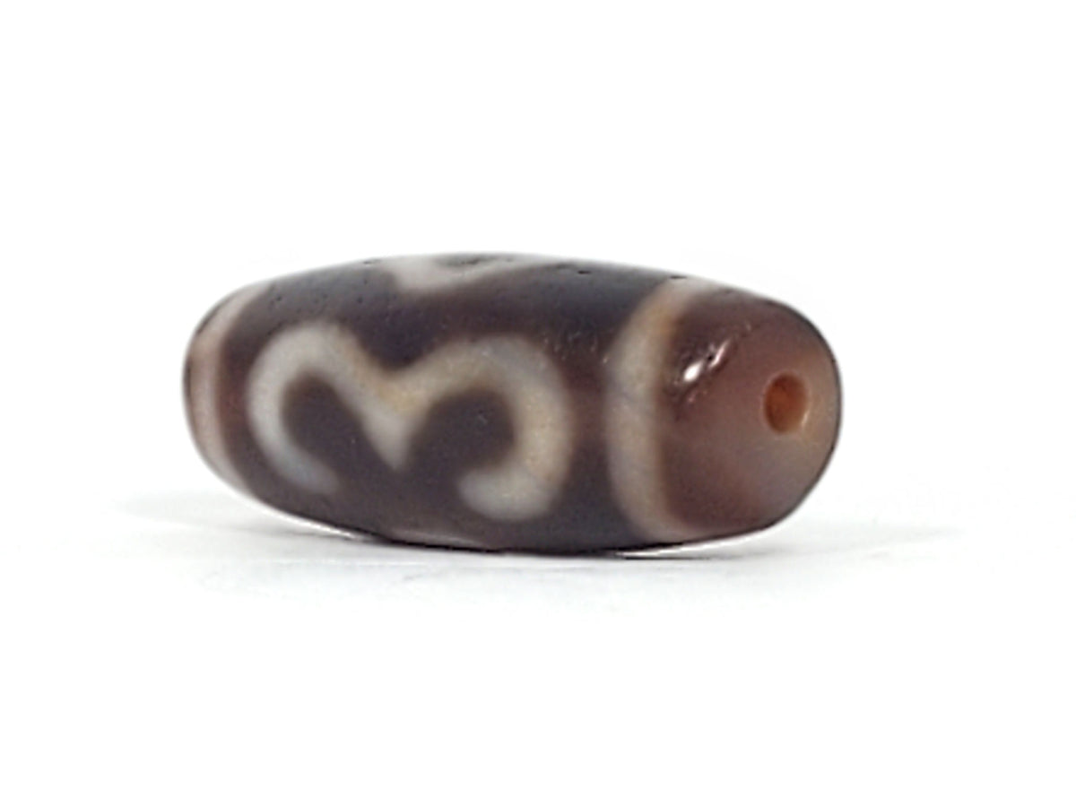 Opposite end detail of antique Double Bat Two Eye dzi At-053026-DB2E, dark brown agate, drill hole, bat and two-eye motif wrapping body, natural weathering marks, unretouched