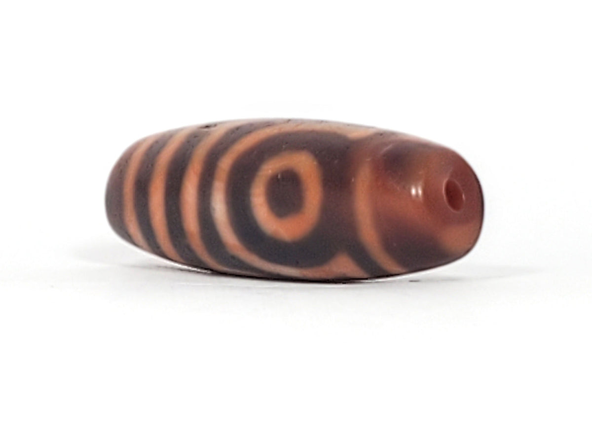 At-053126-2E6, second brick-red end cap with drilled hole, mahogany body, terracotta-orange motif, unretouched
