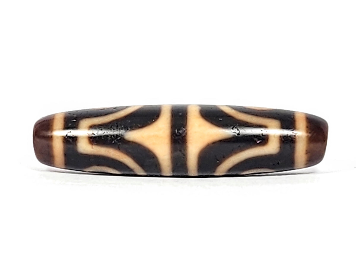 Antique Tibetan dzi bead four-eye tiger tooth motif dark agate cream pattern visible drill hole aged patina