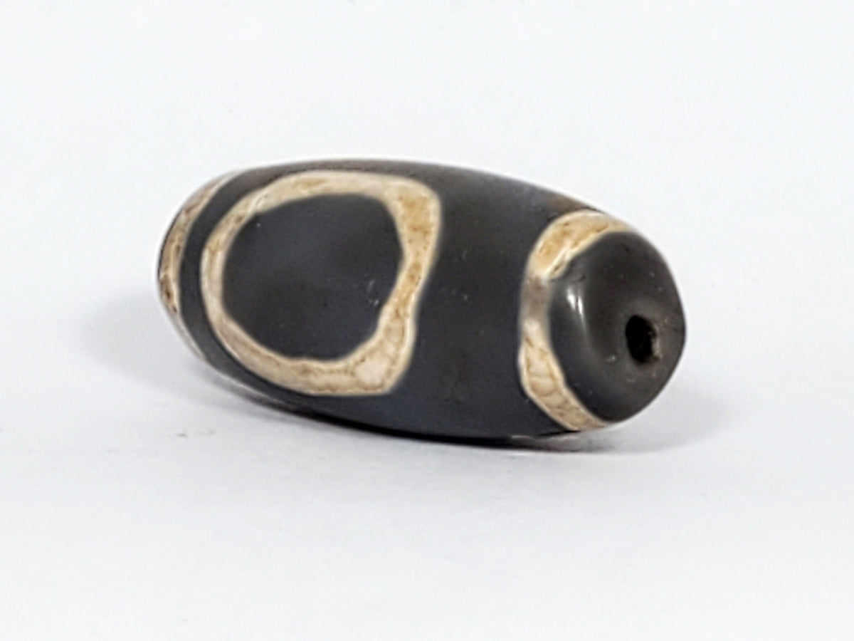 At-022624-HEG, angled End A, charcoal-grey end cap with drilled hole, open oval gate sweeping body, unretouched