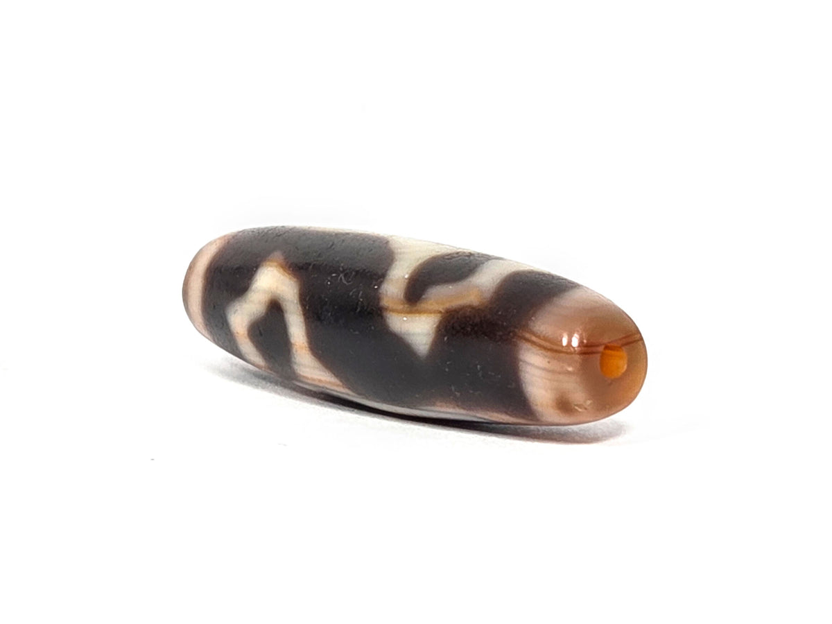 At-072226-LBBS end angle B — opposite warm orange-brown end cap, dark body, cream motif elements, unretouched.