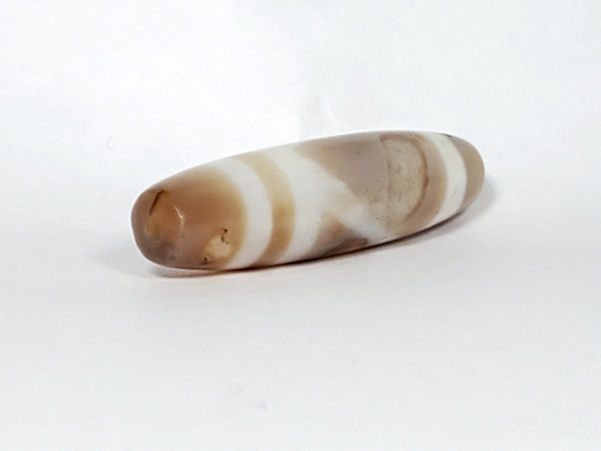 Ancient double mountain dzi bead, banded brown white agate, elongated barrel shape, smooth patina, natural bloodspots visible