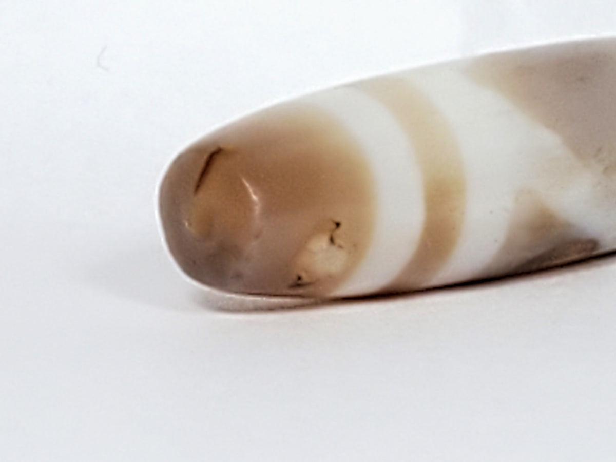 Ancient Tibetan dzi bead double mountain motif, banded agate, cream brown patina, visible drill hole, aged surface texture
