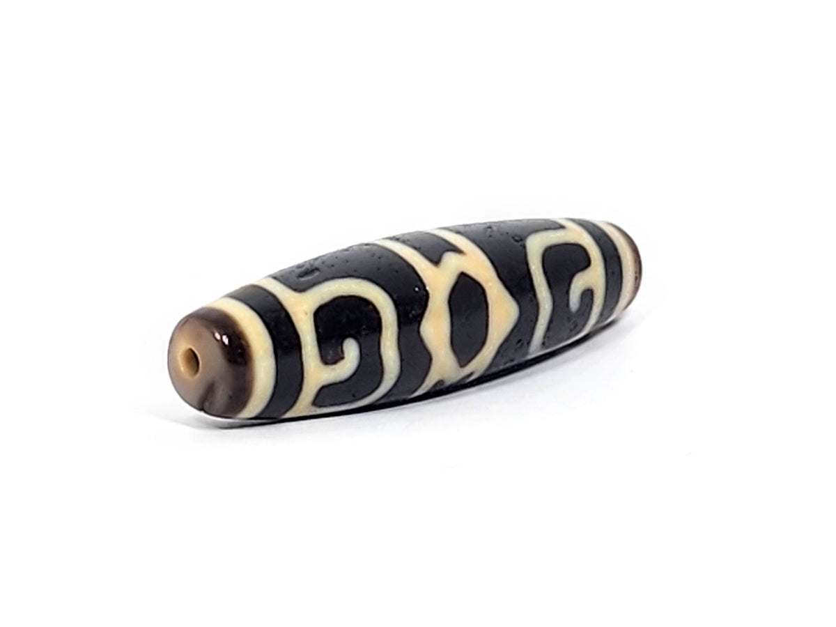 Guru Rinpoche's Dharma Cap Dzi bead, pitch-black agate with cream patterns, 49.8×13.2mm, drilled hole visible
