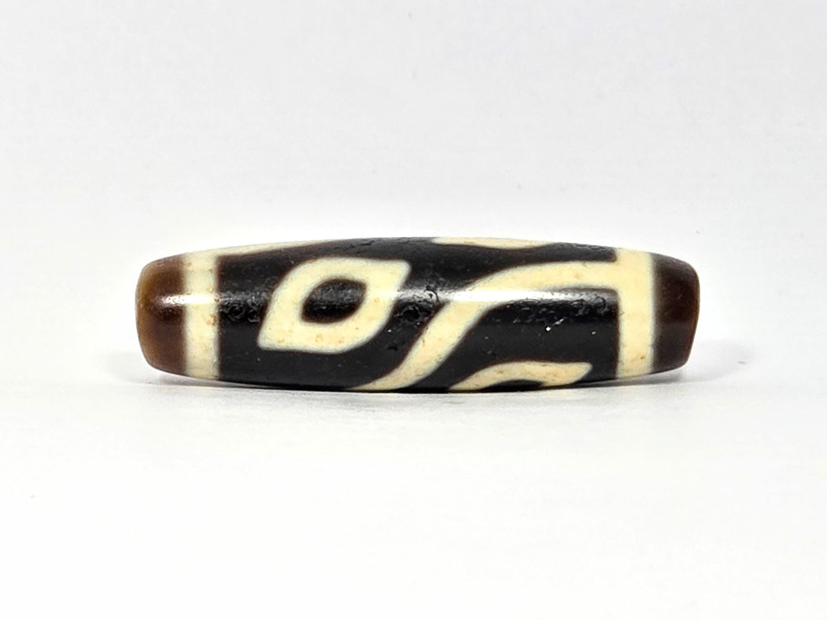 Four eye dzi bead, dark brown and cream agate with natural striping pattern, polished surface, 40mm.