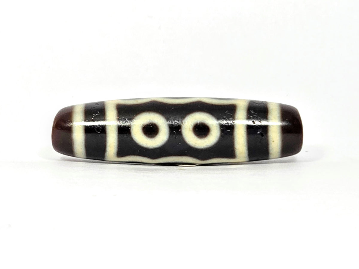 Five-eye dzi bead, dark brown agate, cream white eye motifs, stripe pattern, polished surface, 41mm barrel shape