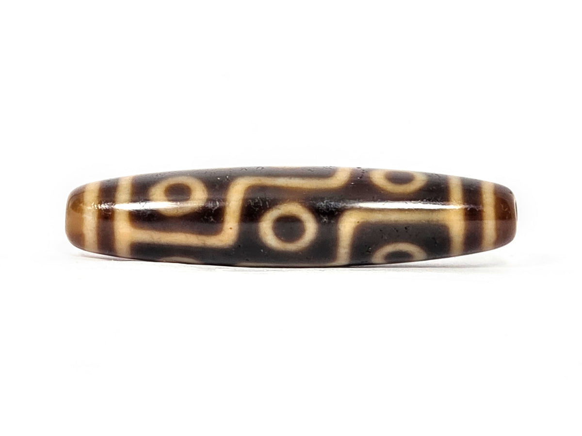 Antique Tibetan nine-eye dzi bead with brown agate and cream striped pattern, polished surface