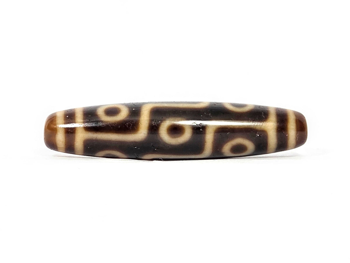 Antique nine-eye dzi bead with brown agate and cream striped pattern, polished surface, side view