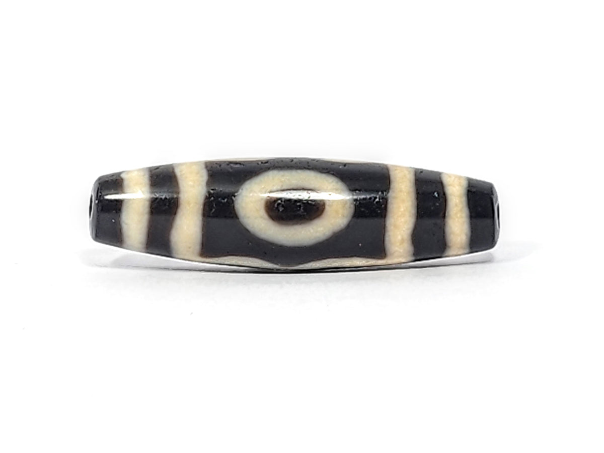Ancient Tibetan 3-eye dzi bead, black agate with cream stripes, central eye motif, visible drill holes, aged patina surface