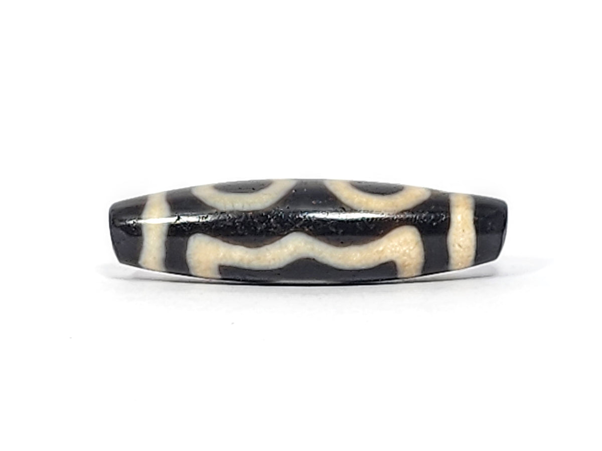 Ancient Tibetan three-eye dzi bead, black agate with cream white eye motifs and wave pattern, aged patina, elongated barrel shape