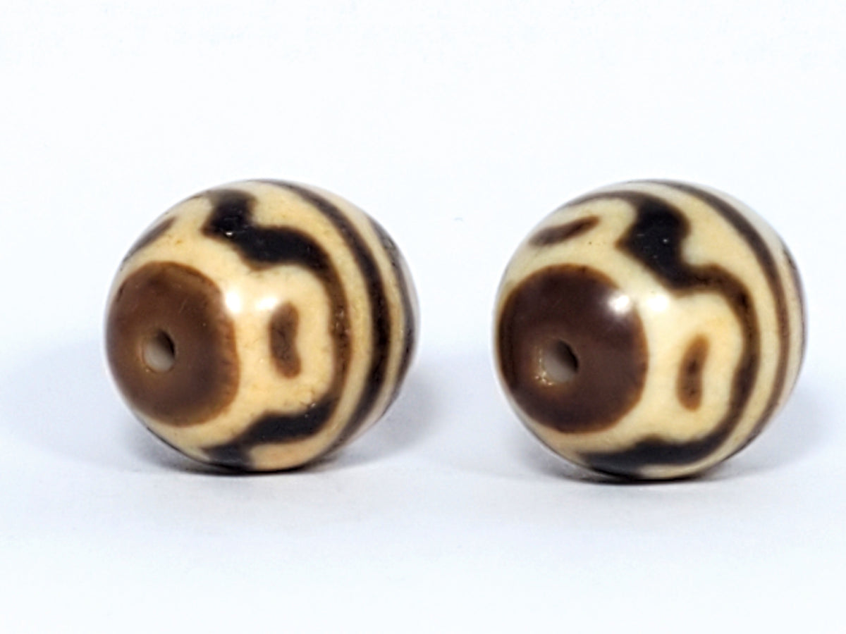 Pair of round tiger tooth lotus dzi beads with cream and brown agate banding and central drill holes