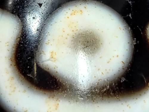 Rare ancient nine-eye Tibetan dzi bead with natural agate patterning, bloodspots, and cream-white coloring