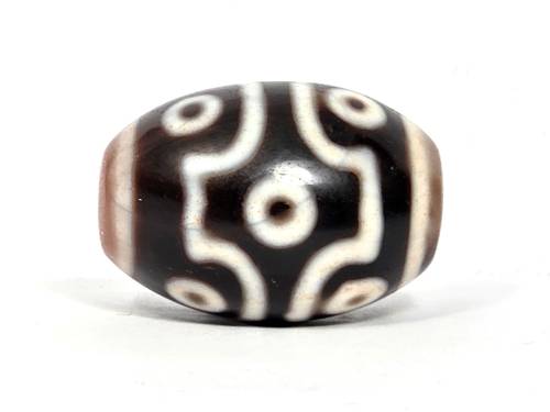 Rare ancient Tibetan nine-eye dzi bead with natural agate striping, cream and black pattern, and visible bloodspots