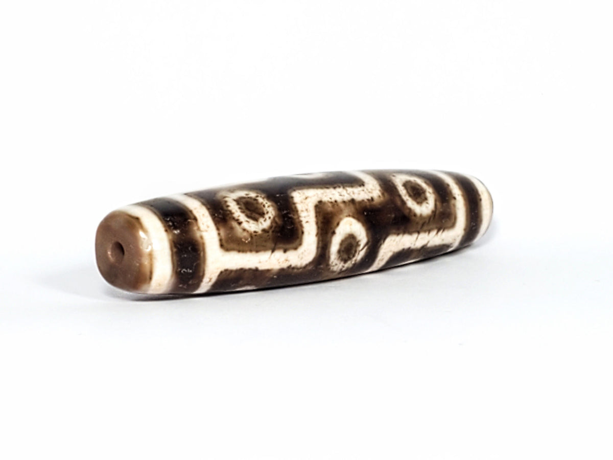 Qing Dynasty nine eye dzi — angled end, drill hole at warm brown rounded tip, S-curve and eye rings on body, At-0426-9EQ