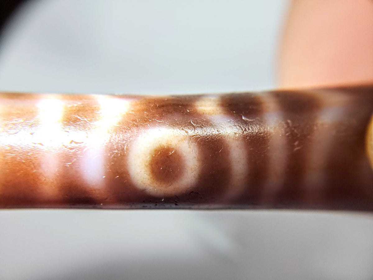 At-082624-6EBS, antique six eye dzi, 54.5×13.2mm, warm rose-brown agate, low-contrast closed eyes, unretouched