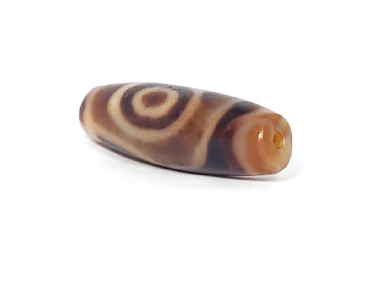 Antique three-eye dzi bead, brown agate, concentric circle motif, white stripe patterning, visible drill hole, natural patina