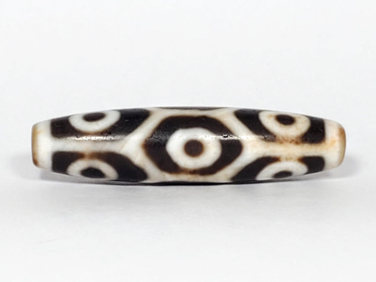 Antique nine-eye dzi bead, black and white agate, eye motifs with lotus pattern, aged patina, elongated barrel shape