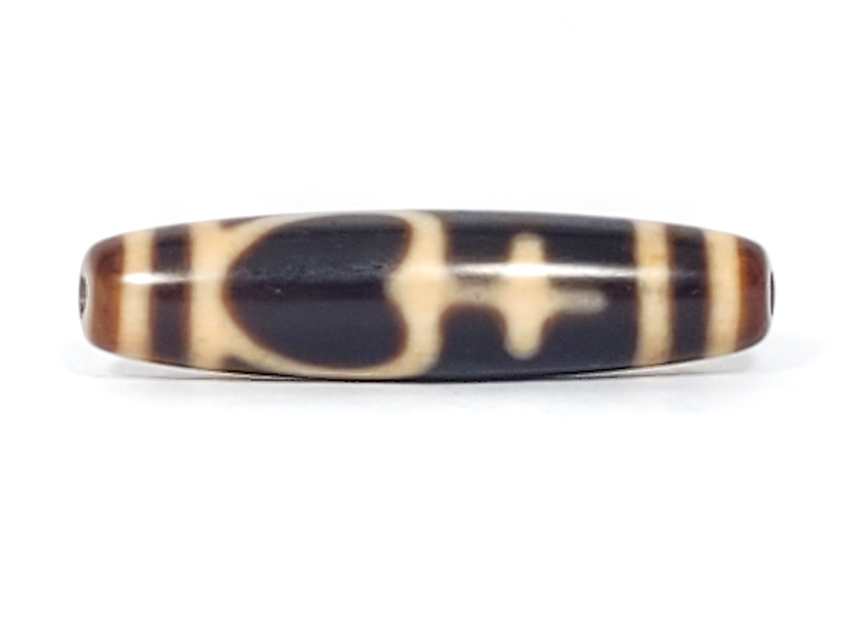 Antique Tibetan dzi bead treasure vase motif, dark agate, cream patterns, visible drill holes, aged patina, elongated barrel shape
