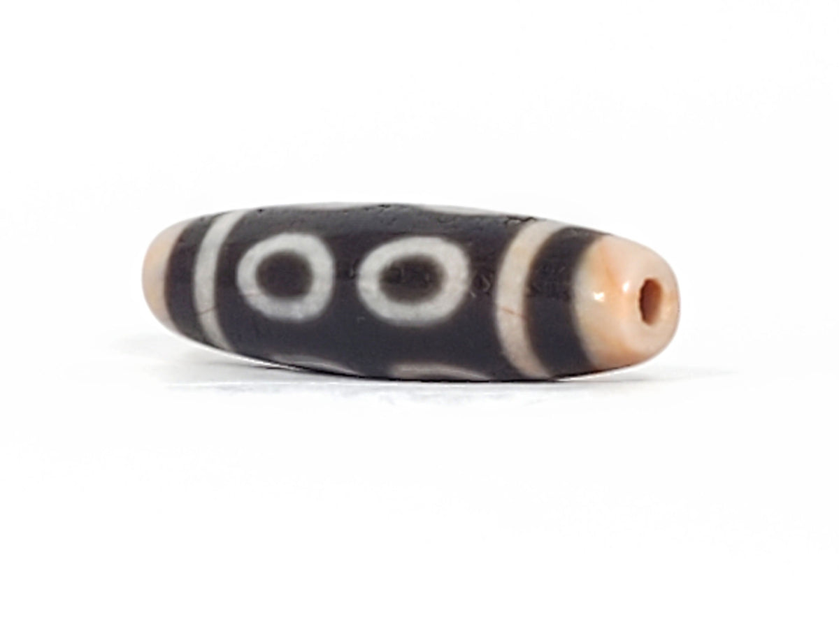 V-092924-8EBS Eight Eye dzi bead, opposite angled end view, peachy-apricot cap, deep dark brown body, unretouched