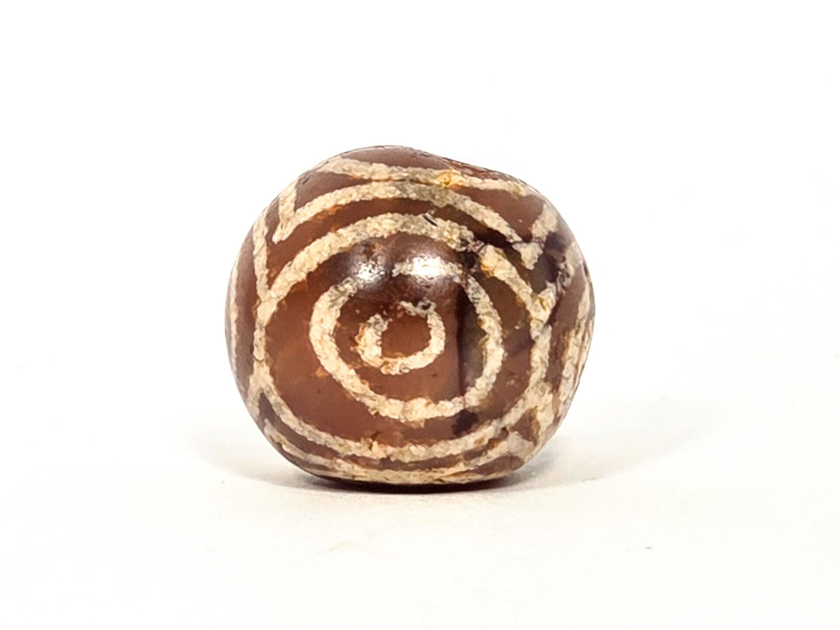 Ac-060126-4EHG, Face D fourth closed concentric eye, chestnut-brown Pema Raka carnelian, drilled hole visible, unretouched