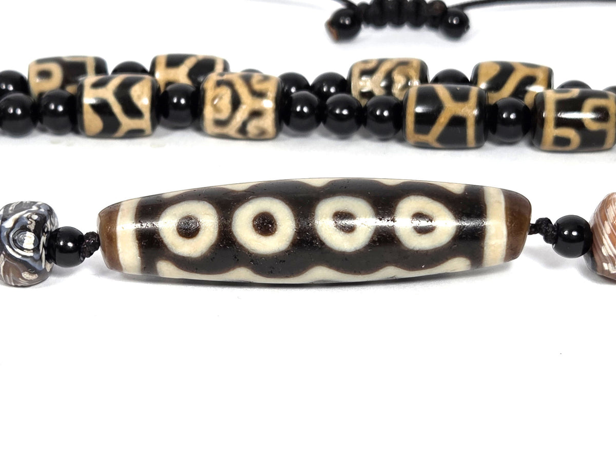 Seven-eye dzi bead necklace, dark brown agate, white eye motifs, wave pattern, aged patina, paired with black onyx spacers
