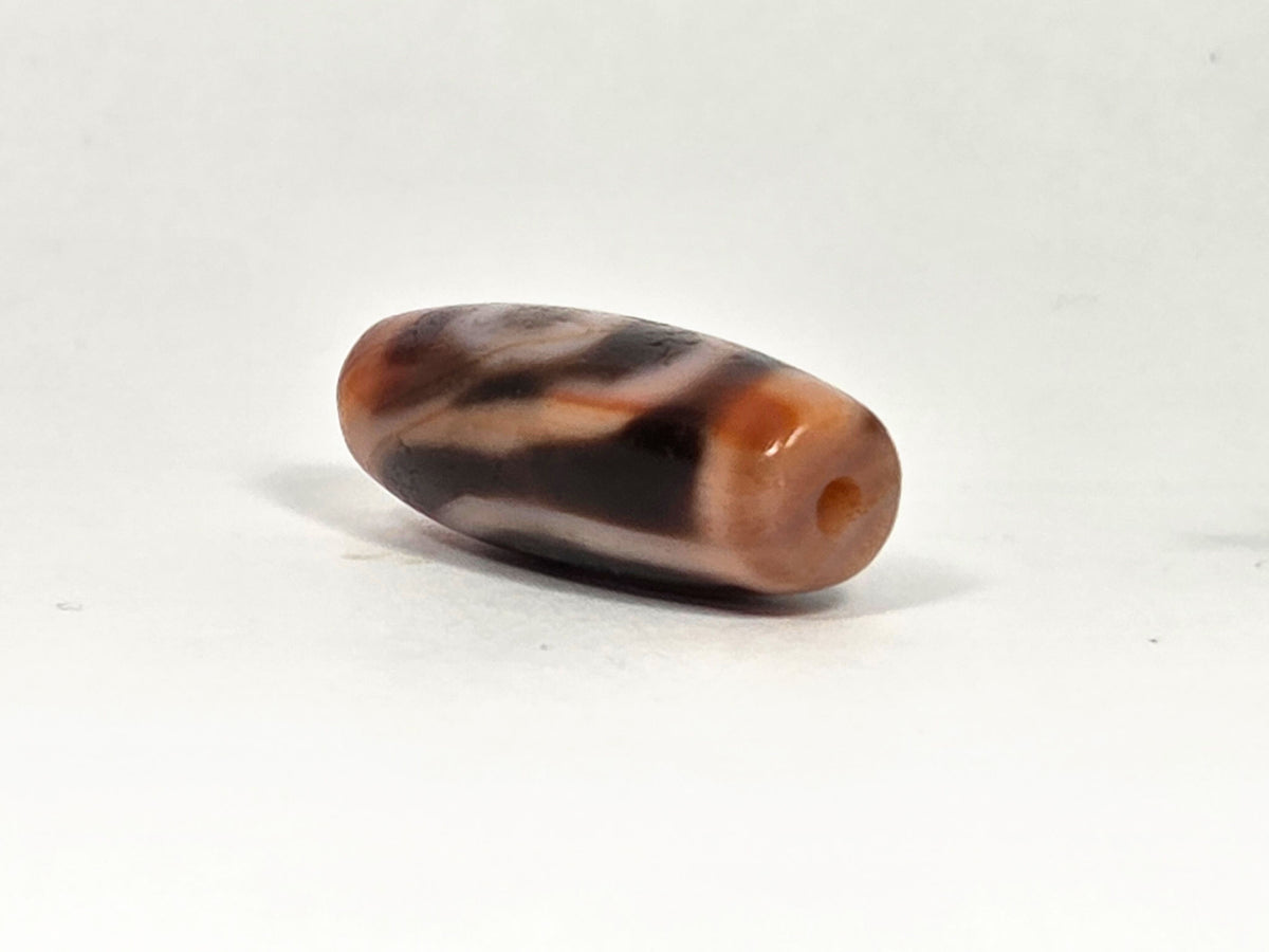 Two-eye dzi bead, reddish-brown agate with natural striping and drill holes, 28.8mm