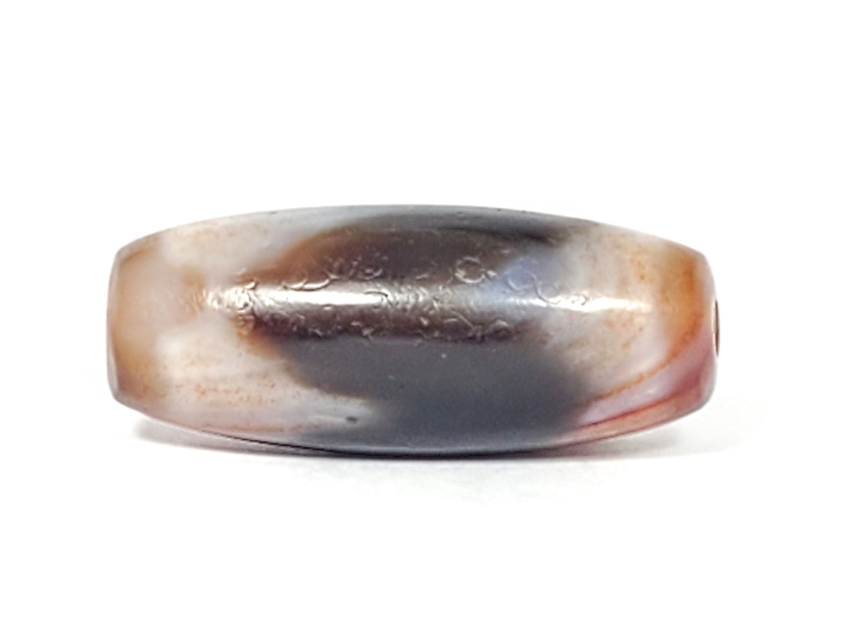 Top profile of antique Tasso dzi bead showing dark grey-black surface with fine weathering marks, At-052526-TaBS